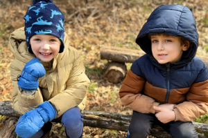  students sitting on a log